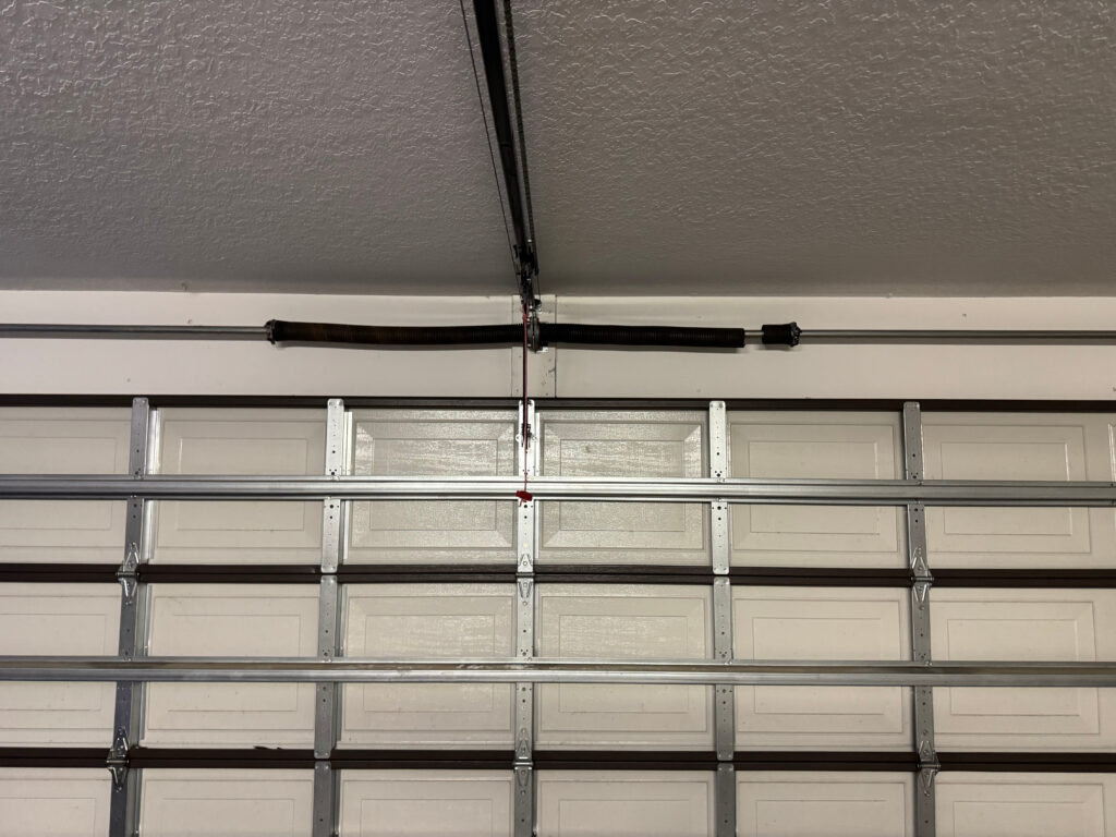 Broken torsion spring with visible gap above residential garage door in Ocala Florida