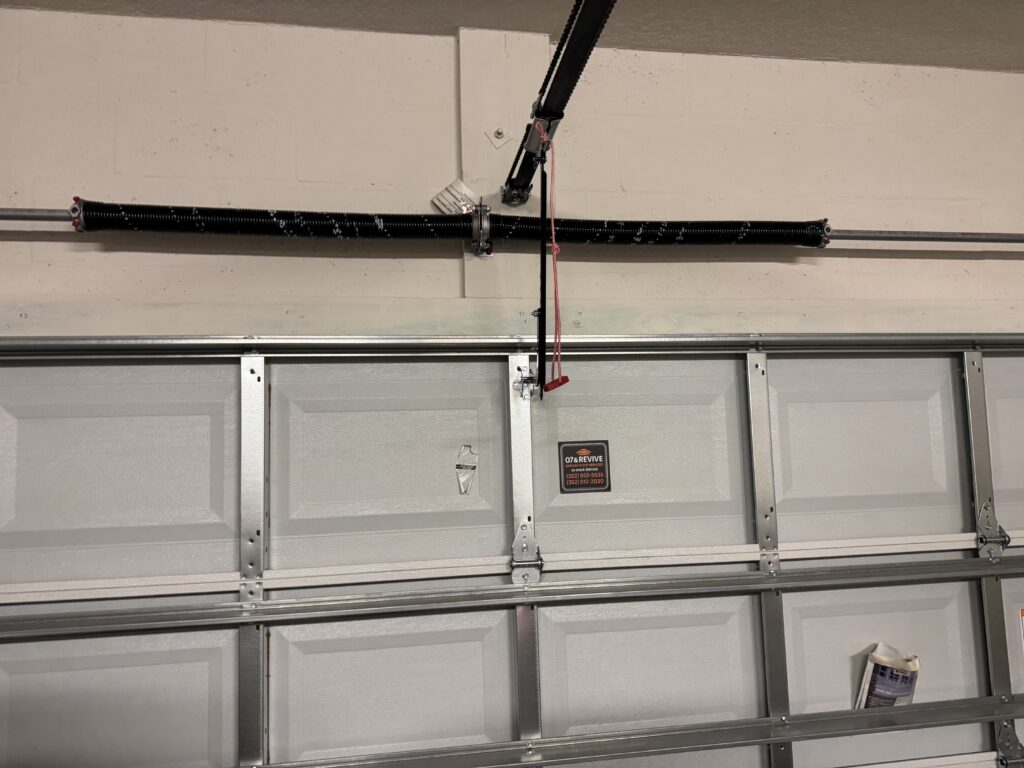 Garage door torsion spring and cable system inside residential garage